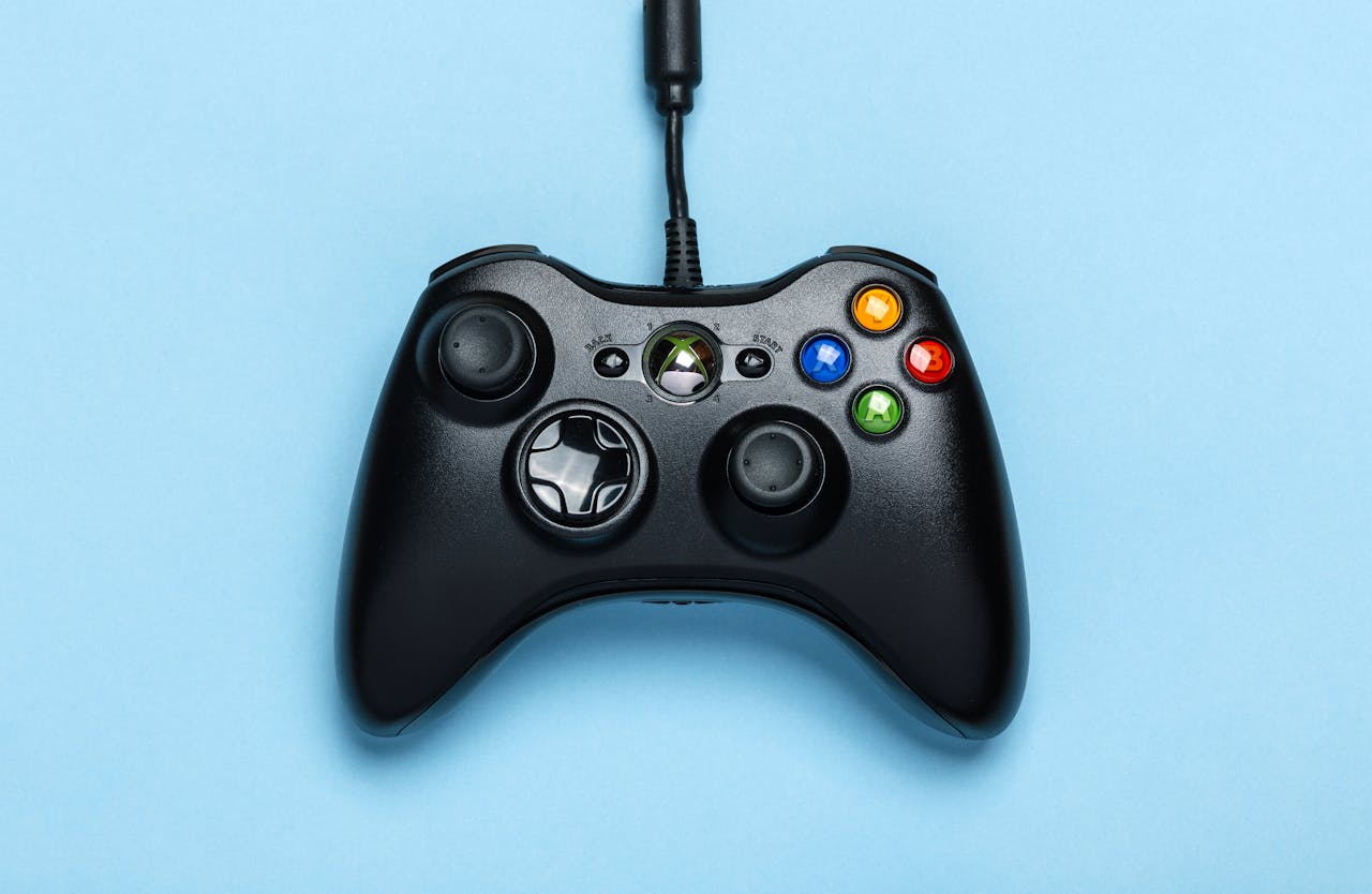 creative-03 Black video game controller isolated on a blue background for gaming enthusiasts.