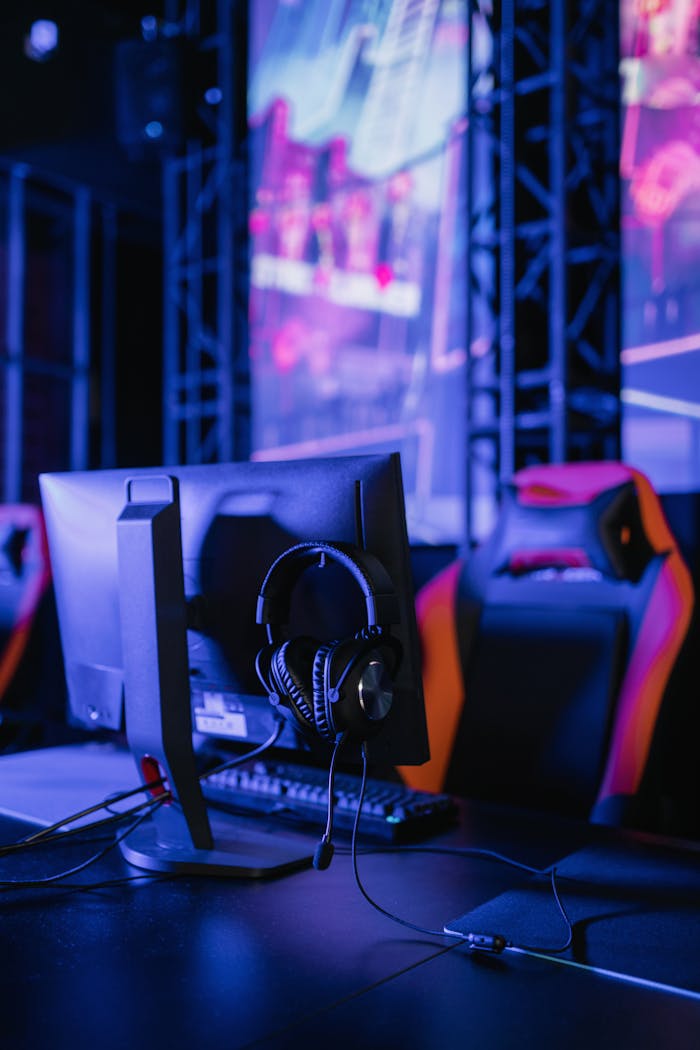 creative-03 A modern gaming setup featuring a computer monitor and headset in a neon-lit environment.